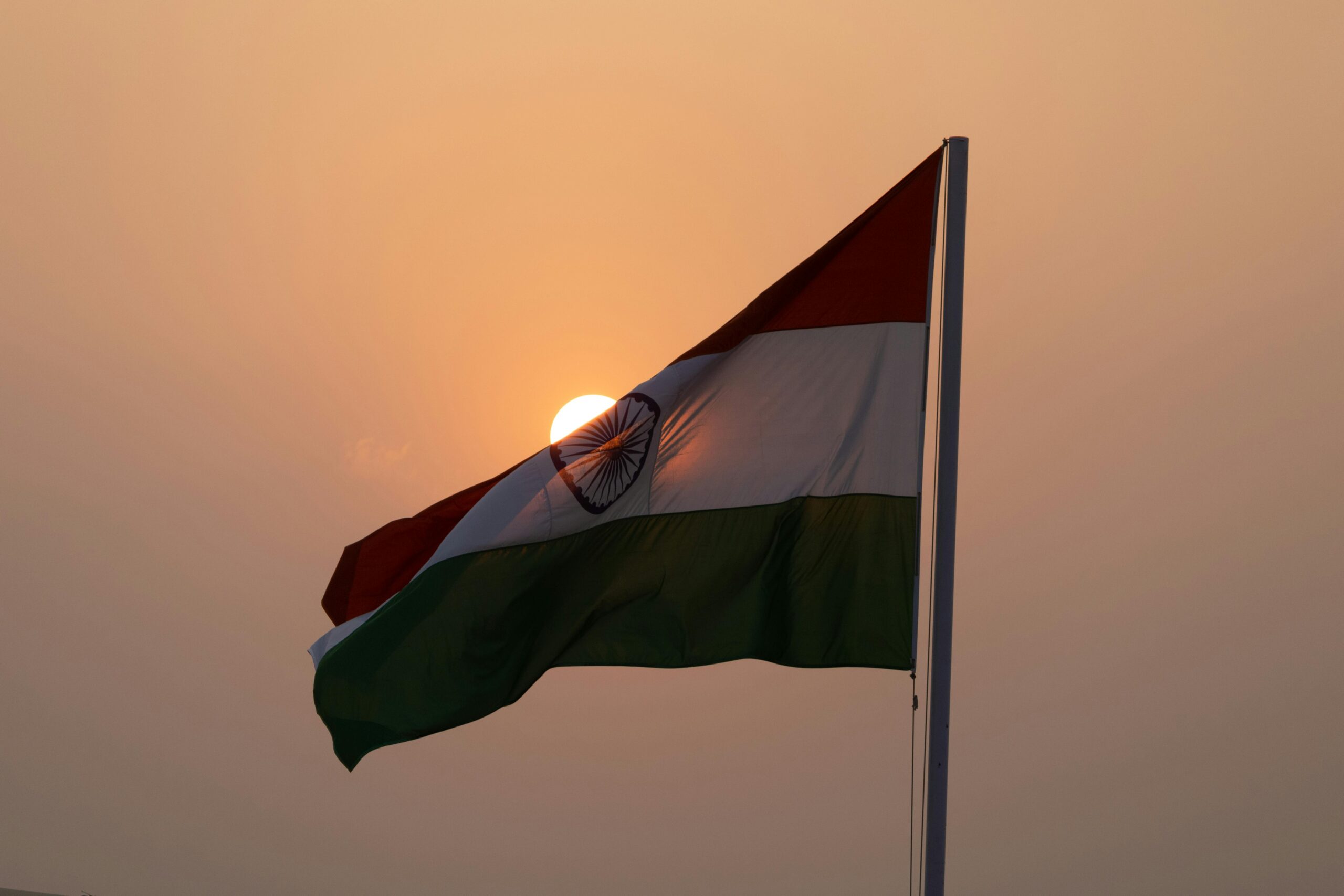The Indian national flag waves majestically against a sunset backdrop, symbolizing patriotism in Lucknow.